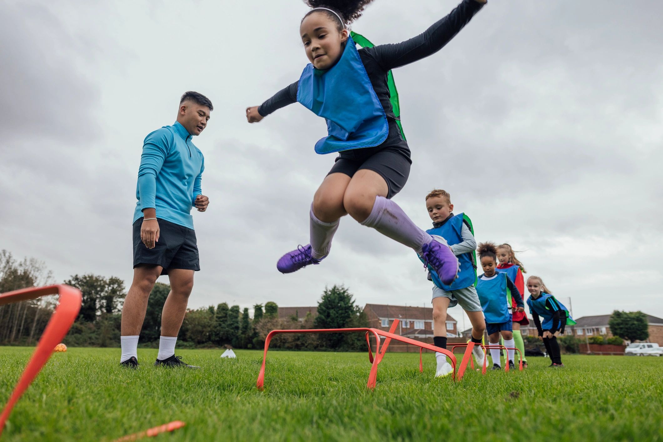 Coach leading youth soccer agility training
