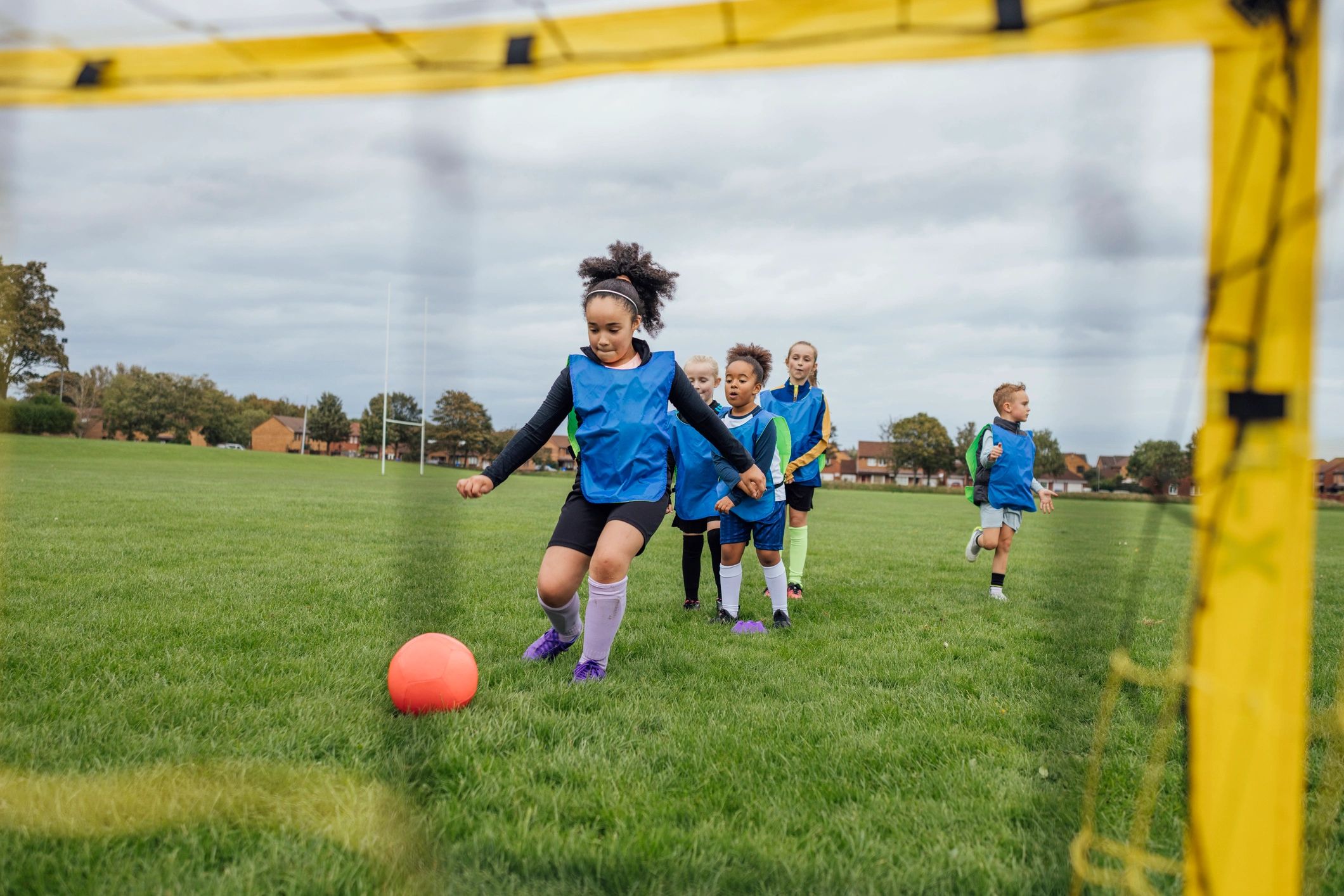 Young soccer players practicing shooting drills at goal